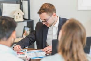 man shows financial documents to man and woman